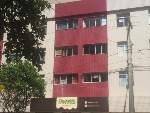 a red building with windows on the side of it at Frente a Praia das Castanheiras in Guarapari