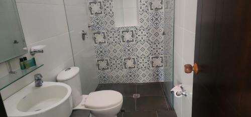 y baño con aseo blanco y lavamanos. en La Estancia del Clavellino, en Los Santos