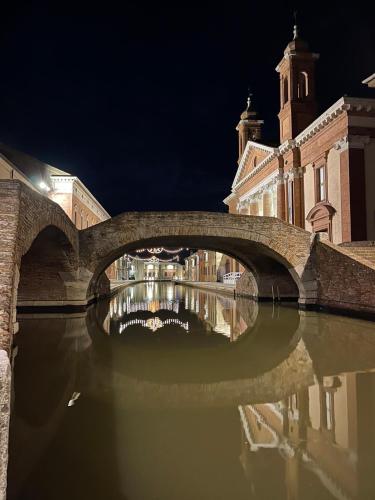 a bridge over a river in front of a building at LA PIAZZETTA in Comacchio