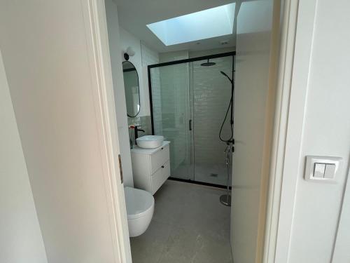 a bathroom with a toilet and a glass shower at La Villa Mandarine sur Arcachon in Arcachon