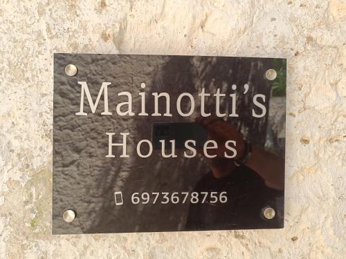 una señal de casas maruthtis en una pared en Mainotti's house with balcony, en Areopoli