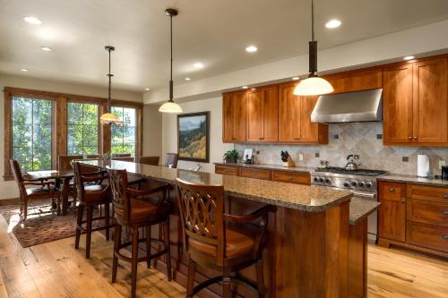 a kitchen with wooden cabinets and a large island with bar stools at The Porches in Steamboat Springs