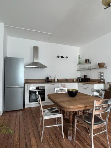 eine Küche mit einem Holztisch und einem Kühlschrank in der Unterkunft Chez La Vieille Dame in Cosne Cours sur Loire