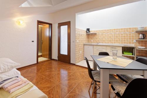 a living room with a table and a kitchen at Apartments Exotica in Funtana