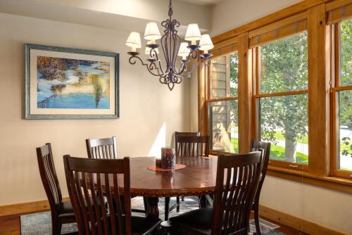 a dining room table with chairs and a chandelier at The Porches in Steamboat Springs