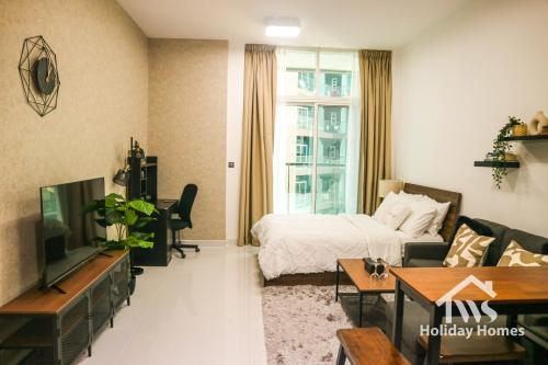 a living room with a bed and a television at The Urban Oasis - Bliss in Dubai