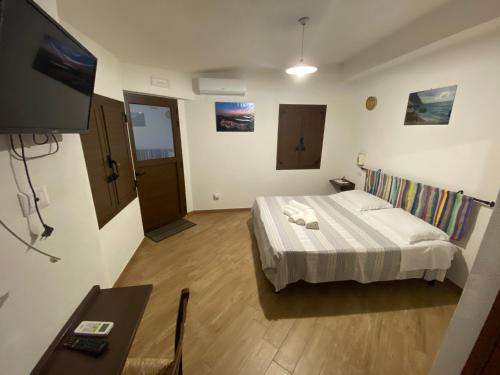 um quarto de hotel com uma cama e uma televisão de ecrã plano em B&b Boladina Experience em Baunei