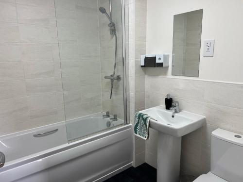 ein Bad mit einer Dusche, einem Waschbecken und einem WC in der Unterkunft Entire House in Littleover Derby in Mickleover