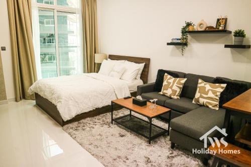 a living room with a bed and a couch at The Urban Oasis - Bliss in Dubai