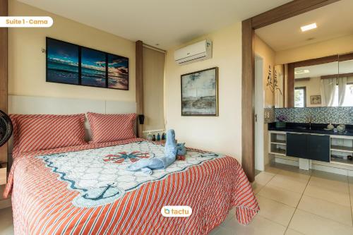 Un dormitorio con una cama con un osito de peluche. en Bangalô frente mar no VG Sun Cumbuco por Tactu en Cumbuco