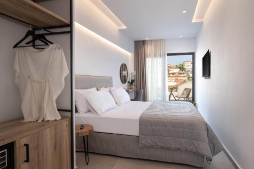 a bedroom with a large bed and a balcony at G Mare Boutique Hotel in Neos Marmaras