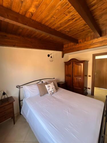 a bedroom with a white bed with a wooden ceiling at Casa Levante Gallipoli in Gallipoli
