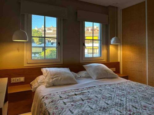 馬貝拉的住宿－Modern 2 bedroom in Marbella Real，一间卧室配有带2个枕头的床和2个窗户。