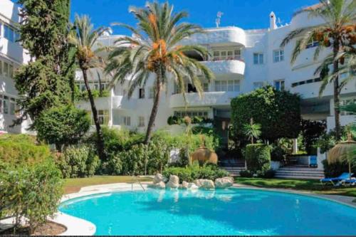 馬貝拉的住宿－Modern 2 bedroom in Marbella Real，一座大建筑前的游泳池