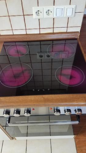 a stove top oven with pink dishes in it at Ferienwohnung Panoramaweg in Sohren