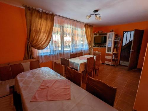 a dining room with two tables and a television at Casa ALINA ȘI ANDREEA in Arieşeni
