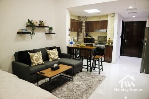 a living room with a couch and a kitchen at The Urban Oasis - Bliss in Dubai