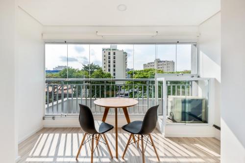d'un balcon avec une table et deux chaises. dans l'établissement Tabas - Edifício Walk SP, à São Paulo