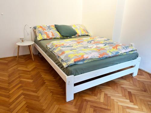 a bed in a room with a wooden floor at Apartmán Pod Vyhlídkou in Nové Město nad Metují