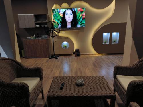 sala de estar con TV de pantalla plana en la pared en Villa campestre Meqo, en Ríohacha
