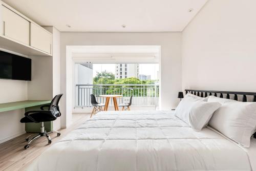 a white bedroom with a large bed and a balcony at Tabas - Edifício Walk SP in São Paulo