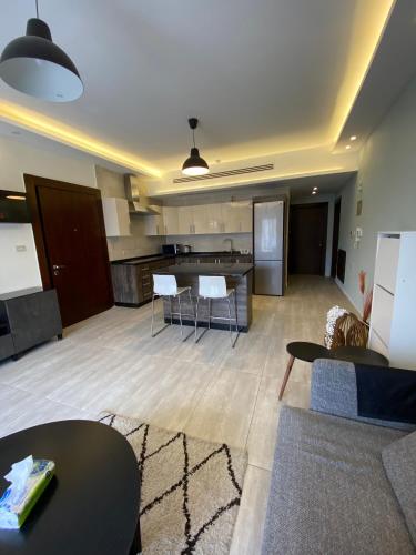 a living room with tables and chairs and a kitchen at Luxurious Rooftop Appartment in Amman