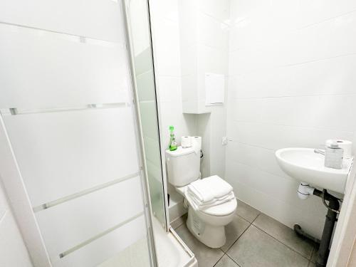 ein weißes Bad mit einem WC und einem Waschbecken in der Unterkunft Société Key-s/Meaux/Suite2-Rhapsody in Meaux