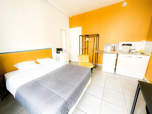 um quarto com uma cama e uma parede amarela em Société Key-s/Meaux/Suite2-Rhapsody em Meaux