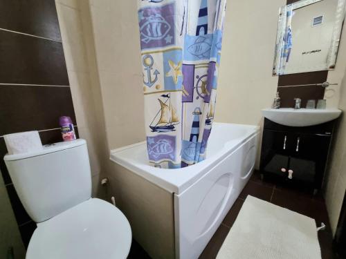 a bathroom with a white toilet and a sink at Testemiteanu 1 bedroom apartment with work zone in Chişinău