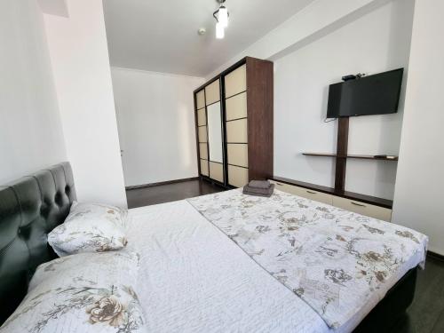 a bedroom with a bed and a flat screen tv at Testemiteanu 1 bedroom apartment with work zone in Chişinău