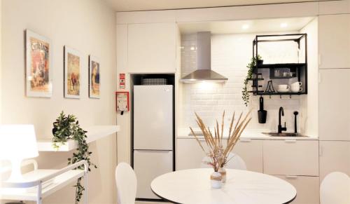 - une cuisine blanche avec une table et un réfrigérateur dans l'établissement Naty Studio with Terrace, à Vila Nova de Famalicão