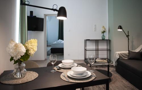 a living room with a table with plates and wine glasses at Apartamenty Emilia in Gniezno