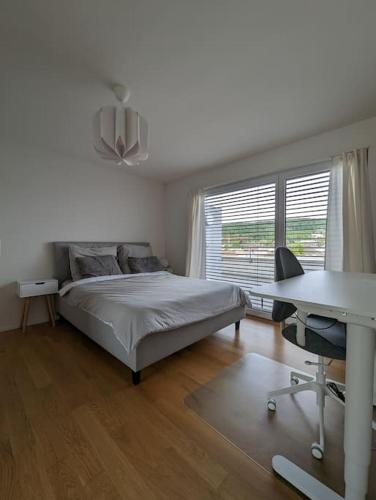 a bedroom with a bed and a desk and a table at Modern Roof-Top with Terrace & View in Zurich