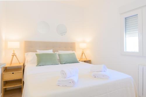 a bedroom with a white bed with towels on it at For You Rentals Acogedor Apartamento en Madrid SAZ31 in Madrid
