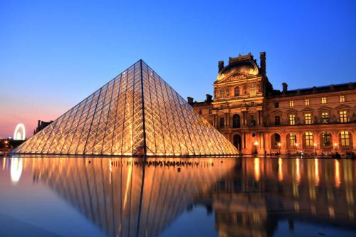 um edifício com uma pirâmide de vidro em frente a um edifício em Société Key-s/Meaux/Suite2-Rhapsody em Meaux