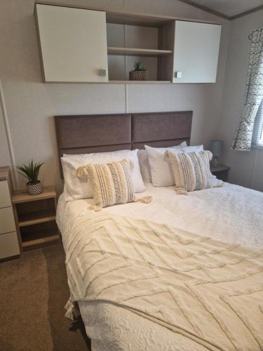a bedroom with a large bed with white sheets and pillows at 18 Rannoch in Forfar