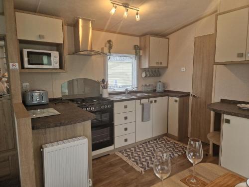 une cuisine avec un évier et une cuisinière four supérieur dans l'établissement 18 Rannoch, à Forfar