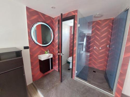 y baño con ducha, lavabo y espejo. en Hotel Boutique San Sebastián Chapinero, en Bogotá