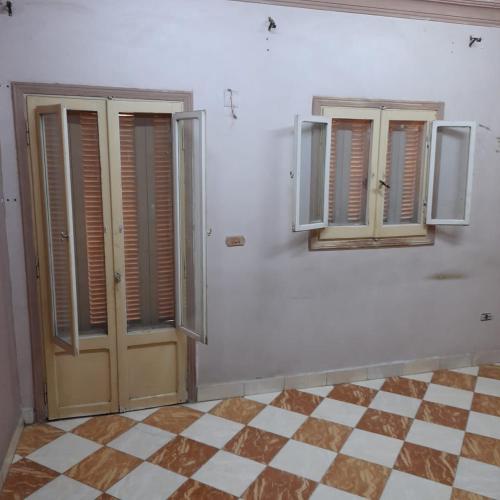 a room with two doors and a checkered floor at شقه للايجار جاهزه بالكامل in Cairo