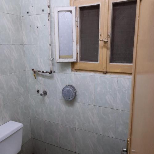 a bathroom with a toilet and a window at شقه للايجار جاهزه بالكامل in Cairo
