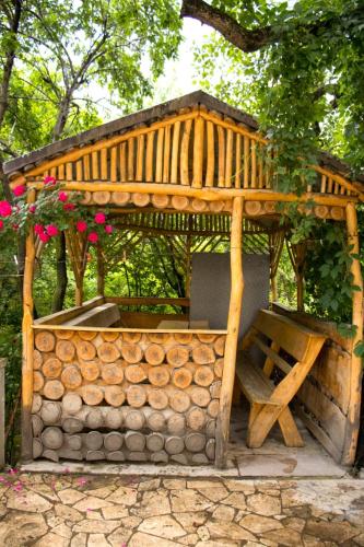 einen hölzernen Pavillon mit einem Tisch und Blumen in der Unterkunft Lucy B&B in Garni