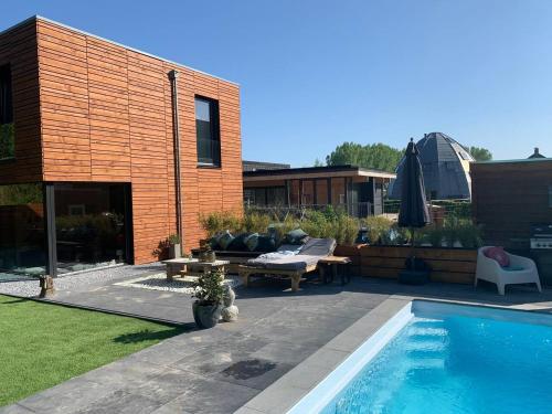 een achtertuin met een zwembad en een huis bij Villa Meijer in Almere