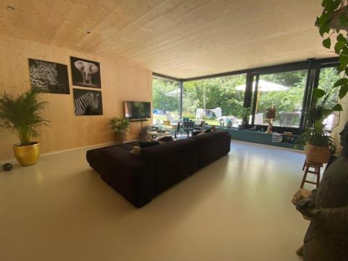 uma grande sala de estar com um sofá e uma mesa em Villa Meijer em Almere