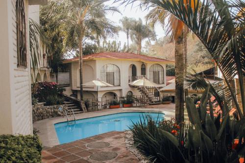 uma casa com piscina em frente a uma casa em Hotel Ilebal em Cuernavaca