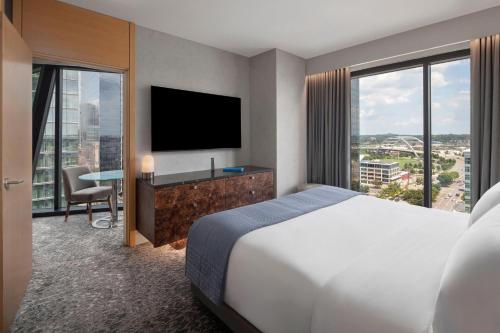a hotel room with a bed and a flat screen tv at The Joseph, a Luxury Collection Hotel, Nashville in Nashville