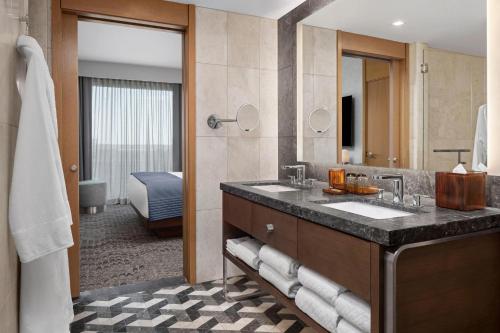 a bathroom with a sink and a large mirror at The Joseph, a Luxury Collection Hotel, Nashville in Nashville