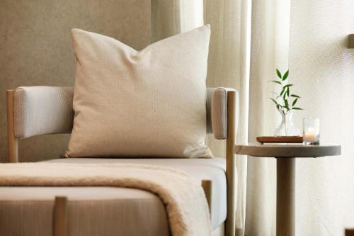 a pillow sitting on a chair next to a window at The Joseph, a Luxury Collection Hotel, Nashville in Nashville