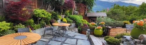 a patio with a table and an umbrella in a garden at La Bergerie du Miravidi in Bourg-Saint-Maurice
