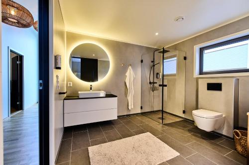 a bathroom with a toilet and a sink and a mirror at Lofoten panorama luxury home with sauna in Reine in Reine