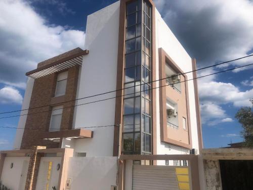 a building with glass windows on the side of it at Résidence le corail de chat meriem in Sousse